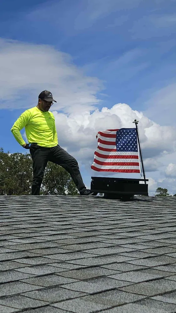 Arctic Attic technician standing beside a completed solar attic fan installation
